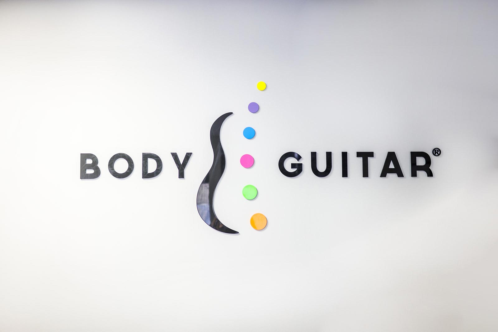 Body Guitar Clinic wall mark: BODY, guitar curve, six tuner dots, GUITAR